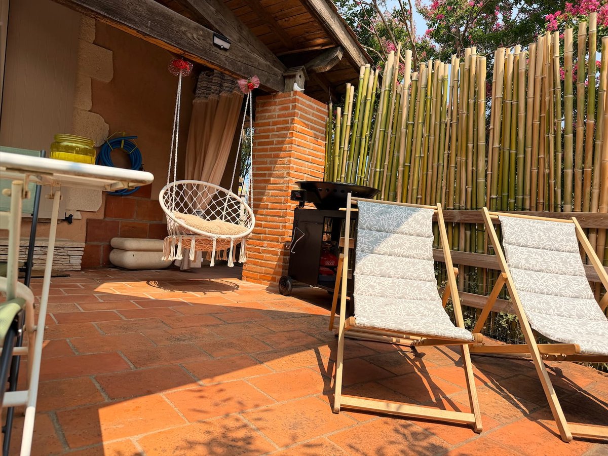 Terrasse de Lou Pitchoun avec fauteuil suspendu et transats